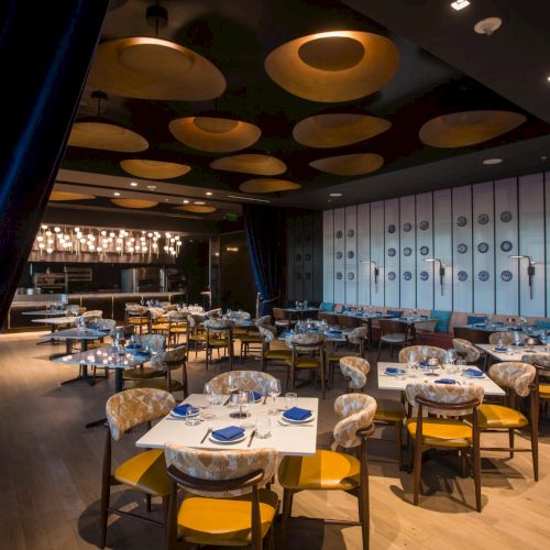 A cozy restaurant with warm lighting, wooden tables and chairs, plush booths, and a rustic, intimate dining atmosphere.