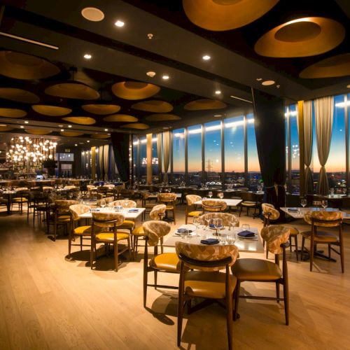 A cozy bar or lounge with warm lighting, seating and tables, a stage area, and a relaxed evening vibe.